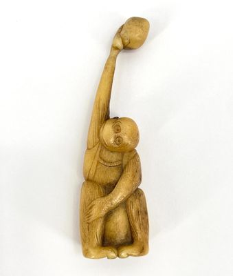 an image of a wooden sculpture of a monkey holding a ball