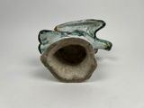 a small vase with a bird on it on a white surface
