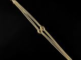 a close up of a gold plated bracelet on a black background