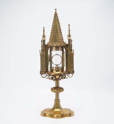 an antique brass clock on a stand with a clock in the middle