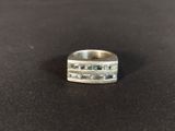 a close up of a silver ring on a black surface