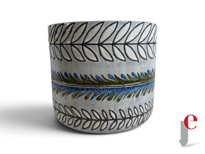 un vase blanc orné d'un motif bleu et vert