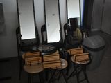 une pièce avec beaucoup de chaises et des miroirs accrochés au mur
