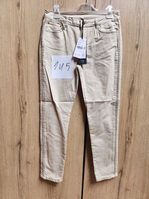 Pantalon femme coloris beige clair, modèle 7/8 avec poches avant décor