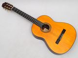 a close up of an acoustic guitar on a white surface