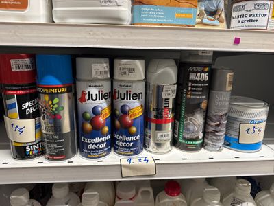 de nombreux pots de peinture sur une étagère dans un magasin