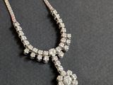 un collier avec une croix en diamant sur un fond noir