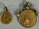 two gold coin pendants with indian head on them sitting next to each other