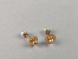 a pair of gold earrings with pearls on them
