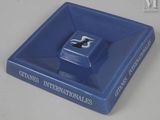 un cendrier bleu sur lequel est posé un livre
