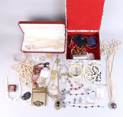 a red box filled with jewelry on a white surface