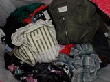 a pile of clothes in a bag on a bed