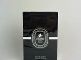 black and white box of perfume sitting on a white surface