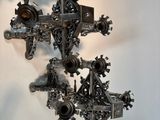 a sculpture of a cross made of metal on a table