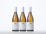 three bottles of white wine sitting on top of a table