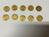 a bunch of gold coins sitting on top of a white table