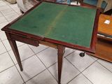 une petite table au plateau vert posée sur un sol carrelé