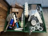 a green container filled with assorted kitchen utensils