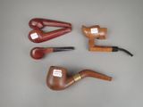 several different types of pipe and pipe holder sitting on a table