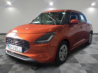 La voiture orange est garée sur un sol à damier dans le garage.