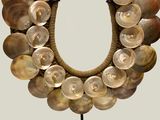 an image of a necklace made out of shells on a stand