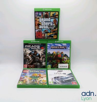 Trois jeux Xbox sont empilés les uns sur les autres sur une surface blanche