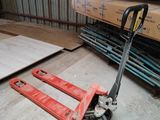 une palette posée par terre à côté d'une pile de bois