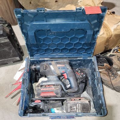 une boîte à outils bleue avec des outils sur le sol