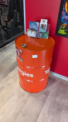 a large orange barrel with magazines on top of it