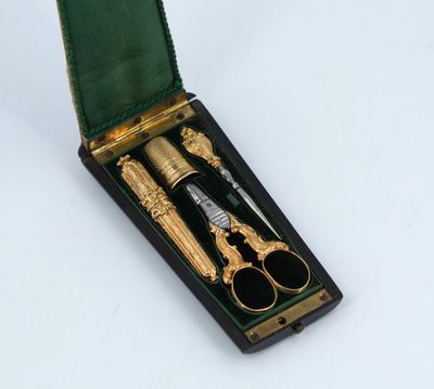 a pair of scissors in a box with a green case