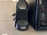 a small black coffee maker sitting on a counter next to a toaster oven
