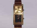 a gold watch with a black face on a brown leather strap