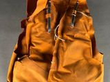 pair of orange vests hanging from a string on a gray background