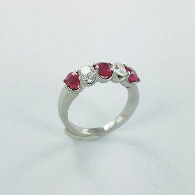 un gros plan d'une bague en or blanc sertie de trois rubis