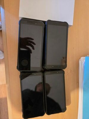 four cell phones that are sitting on a shelf