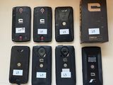 Plusieurs téléphones portables sont alignés sur une table, à côté d'une boîte