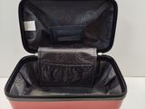 a red suitcase with a black handle on a white table
