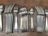 six fourchettes et cuillères sont alignées sur une table en bois