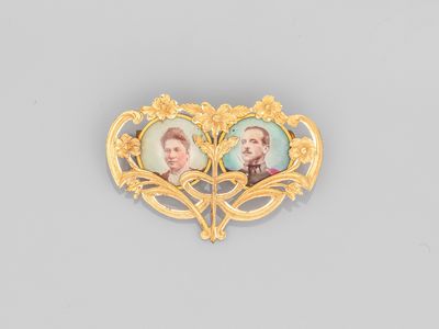 un gros plan sur une broche représentant deux portraits, celui d'un homme et celui d'une femme