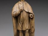 une statue en bois représentant un garçon portant une cape et un manteau