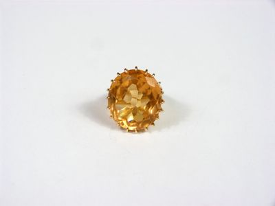 une bague sertie d'un saphir jaune sur un fond blanc
