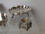 a silver bowl and a silver spoon on a glass table
