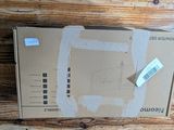 une boîte en carton posée sur une table en bois, sur laquelle est collé un autocollant