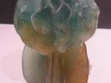 a green and yellow stone sculpture on a white surface