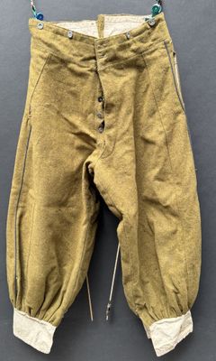 an old pair of pants hanging on a hanger on a wall
