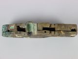 a close up of a piece of metal with a green stone in it