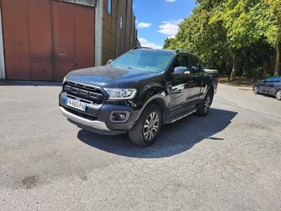La Ford Ranger noire est garée devant un immeuble.