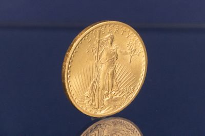 une pièce d'or posée sur une surface bleue