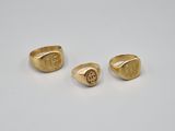 a pair of gold rings with the initials of a man and a woman