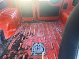 a red truck bed with a black floor and a red door